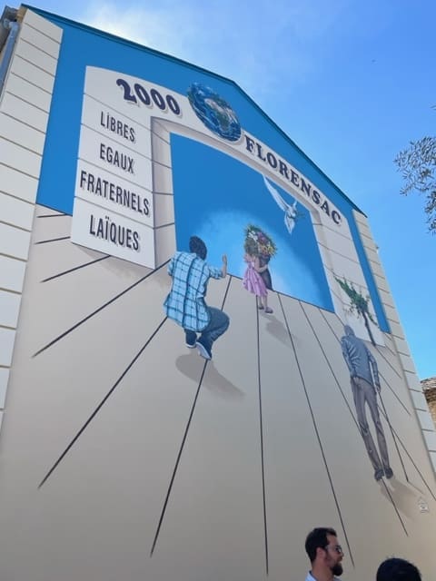 Fresque à Florensac : Libres, Egaux, Fraternels, Laïques. Personnages et colombe illustrant les valeurs républicaines.